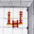 Bird cage with hanging toy made of wood and metal chains, red and yellow elements in geometric shapes.