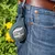 Nomad Tales Ballhalter mit schwarzem Tennisball, befestigt an einer Jeans-Gürtelschlaufe. Markenname 'Nomad Tales' sichtbar auf dem Ball.