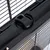 Close-up of a black locking mechanism on a metal grid cage, with arrows for operating instructions visible on the lock.