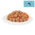 Close-up of wet food pieces with carrots on a white plate. Fish symbol in the top right of the image.