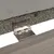 Närbild av ett metallgångjärn som förbinder två träplattor. Ovansida med synlig grusbeläggning.