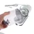 Hand holding a removable container of a device with visible filter and power cable in the background.