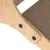 Gros plan sur une structure en bois clair avec surface en carton ondulé fixée par des vis noires, matériaux visibles : bois et carton.