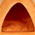 Intérieur d'une niche ou maison pour animal en tissu orange, coussin rembourré visible à l'intérieur. Aucun texte ni marque apparente.