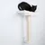 Tiragraffi da parete con cuscino bianco e colonna in sisal. Gatto nero sdraiato sulla piattaforma superiore.