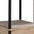 Detailansicht einer Plattform aus Holz mit weicher, beiger Polsterung und schwarzen Metallstreben.