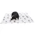 Chien couché sur une couverture blanche en tissu à motifs de têtes de chiens de différentes races.