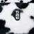 Tiaki logo on black and white faux fur with cow pattern.