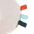 Round plush toy with soft surface and coloured fabric tabs in red, light blue and dark green.