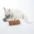 Gato blanco juega con juguete de peluche gris y marrón. Muestra el uso de juguete para gatos.