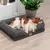 Kutya egy szürke, párnázott szélű kutyaágyon fekszik. Látható a 'Pet Comfort' feliratú fa címke.