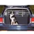 Dog sitting in the boot of a car with installed safety grille partition for secure transport.