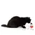 Chat noir à côté d’un distributeur de croquettes transparent et rouge, quelques croquettes éparpillées au sol autour du jouet.