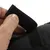 Detailní záběr na černý suchý zip otevíraný rukou. Ukazuje funkci uzavíracího mechanismu.