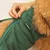 kooa chaleco para perro en verde con cremallera, primer plano de una mano cerrando la cremallera.