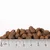 Brown dry pet food kibble pieces shown with a ruler in centimetres, size range approximately 1–2 cm each piece. No visible brand or text.
