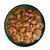 Chunks of meat in gravy with visible peas and carrot pieces served in a bowl, showing the texture and ingredients of the wet pet food.