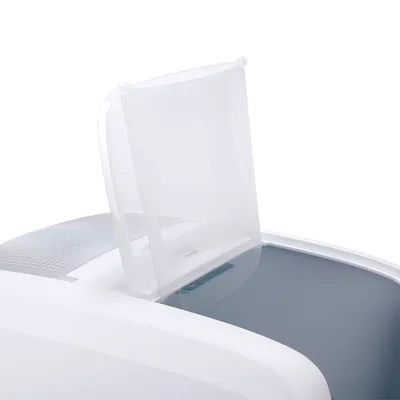 Couvercle en plastique transparent ouvert sur une litière ou bac blanc, vue rapprochée du mécanisme d’ouverture.
