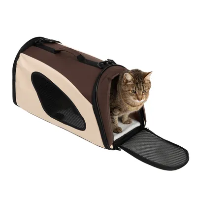 Sac de transport beige et marron en tissu avec grille d’aération latérale, porte avant ouverte, chat tigré assis à l’intérieur sur un tapis blanc.