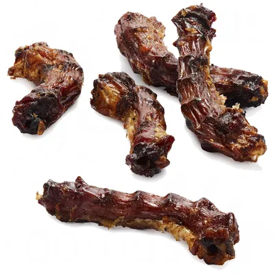 Fem tørrede kødbenformede snacks med mørkebrune og gyldne nuancer, uden synlig emballage eller mærkning.