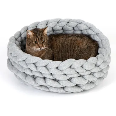 Graues, geflochtenes Katzenbett mit einer braunen Katze darin. Rundes Design aus weichem Material.