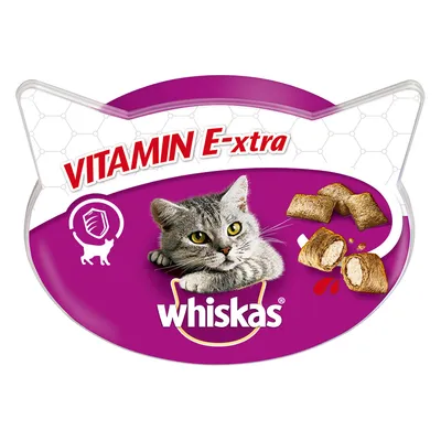 Envase de Whiskas con imagen de gato gris, trozos de snack relleno y texto visible: 'VITAMIN E-xtra'. Incluye icono de escudo y gato. Marca Whiskas claramente mostrada.