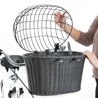 Cestino in vimini grigio per bicicletta con cupola di protezione in metallo nero, fissato al manubrio. Una persona apre la cupola tramite le cinghie visibili.