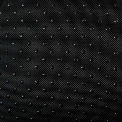 Dettaglio di tessuto nero con superficie a rilievo e piccoli punti antiscivolo visibili.
