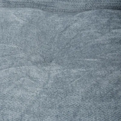 Dettaglio primo piano di tessuto grigio con trama visibile, imbottito e leggermente trapuntato, materiale per cuccia o cuscino per animali.