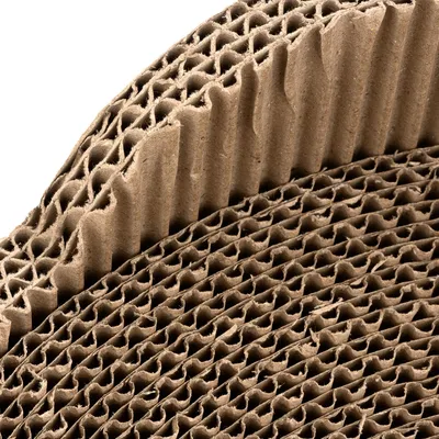 Gros plan sur du carton ondulé marron, structure en nid d’abeille visible. Aucun texte ou marque apparente.
