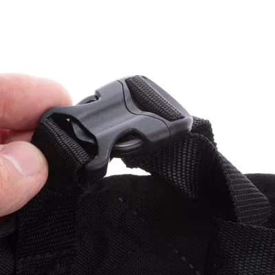 Nahaufnahme eines schwarzen Kunststoffverschlusses an einem robusten, schwarzen Nylonband. Verschluss wird von einer Hand gehalten.