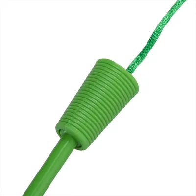 Detail zeleného plastového držadla s povrázkom, pravdepodobne časť hračky pre domáce zvieratá. Viditeľný vrúbkovaný povrch a pripevnený zelený špagát.