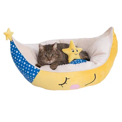 Cama para gatos en forma de luna amarilla con detalles azules y blancos de estrellas, incluye cojín en forma de estrella sonriente. Gato atigrado tumbado dentro de la cama.
