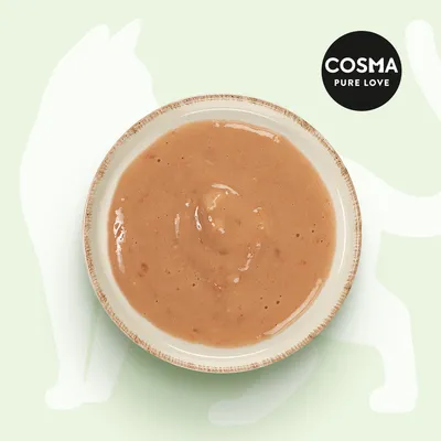 Cosma Pure Love. Miseczka z kremową mokrą karmą na zielonym tle, widoczny zarys kota.