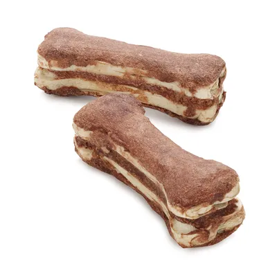 Dwa przekładańce w kształcie kości, brązowo-białe, bez widocznych marek ani tekstu. Produkt spożywczy dla zwierząt.