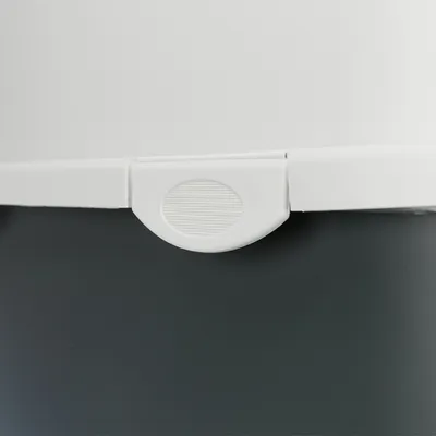 Detailní záběr na bílý uzavírací mechanismus na tmavě šedém pozadí.