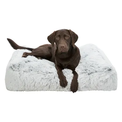 Hond ligt op een rechthoekig, pluizig grijs huisdierenbed. Product toont comfort en design van het bed.