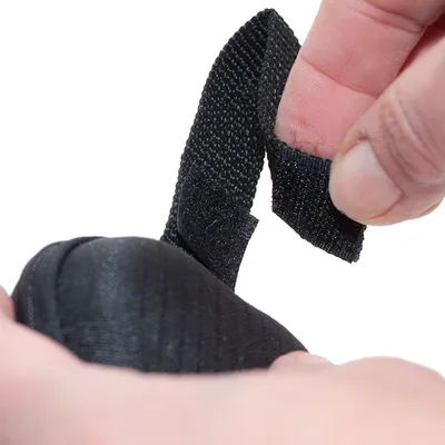 Close-up of a black hook-and-loop fastener being opened by a hand, showing the fastener's function for easy handling.