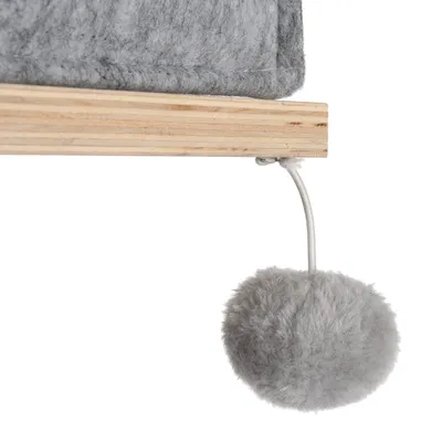 Grå plysbold på en snor, fastgjort til en træplatform med gråt stofbetræk.