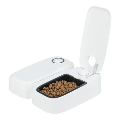 White automatic feeder with open compartment filled with dry food. Timer adjustment dial visible.
