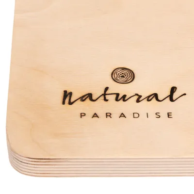 Natural Paradise. Holzgravur mit Markenlogo und Schriftzug auf hellem Holz.