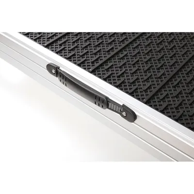 Detailweergave van een aluminium oprijplaat met antislip zwarte oppervlak en draaggreep.