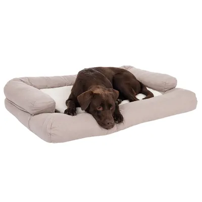 Chien marron allongé sur un grand coussin rectangulaire beige à rebords, surface centrale blanche, tissu aspect doux. Aucun texte ou marque visible.