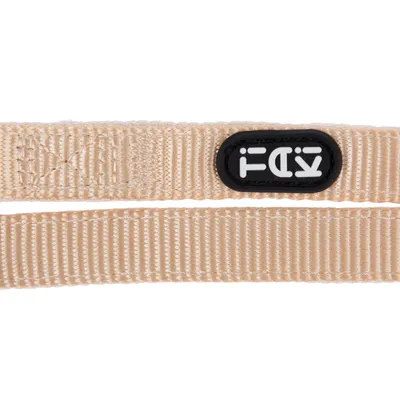 Beiges Nylonband mit schwarzem Logo-Aufnäher 'Trixie'.