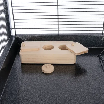 Juguete de madera con tres aberturas y tapas extraíbles, colocado en una jaula de metal. Adecuado para juego interactivo o esconder snacks.