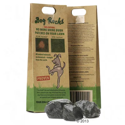 Dog Rocks csomagolás, angol szöveggel: '100% natural, no more urine burn patches on your lawn', két kép előtte-utána gyepfoltról, három fekete kő a csomag előtt.