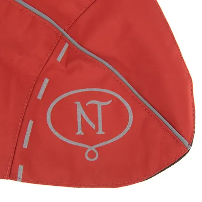 Detail van rood textiel met reflecterende biezen en het opschrift 'NT' in een ovaal, zichtbaar stiksel. Materiaal: stof.