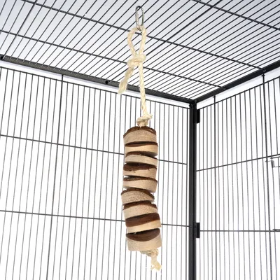 Jouet suspendu en bois et corde naturelle accroché dans une cage à barreaux métalliques, composé de rondelles empilées sur une ficelle nouée avec crochet métallique.