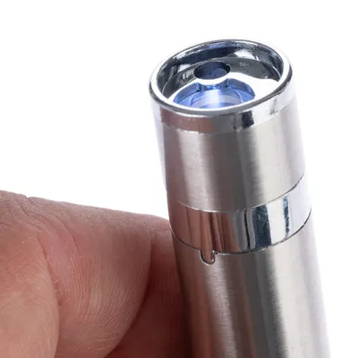 Close-up of a silver laser pointer with blue light, held by a hand.