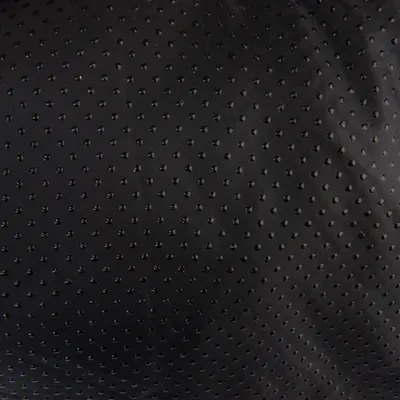 Nahaufnahme eines schwarzen, gepunkteten Stoffmaterials mit strukturierter Oberfläche.